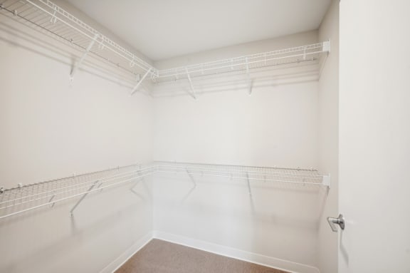 an empty room with white walls and a mirrored closet