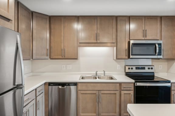 an empty kitchen with wooden cabinets and stainless steel appliances