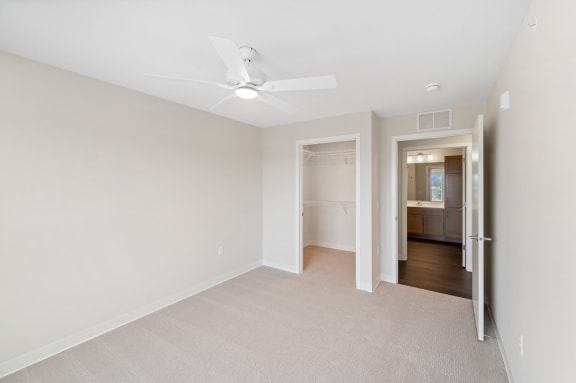 a renovated living room with white walls and a ceiling fan