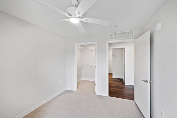 a renovated living room with white walls and a ceiling fan