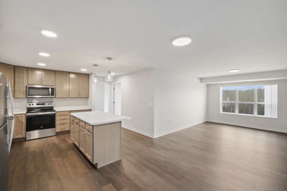 the living room and kitchen in a new home with wood floors and white walls