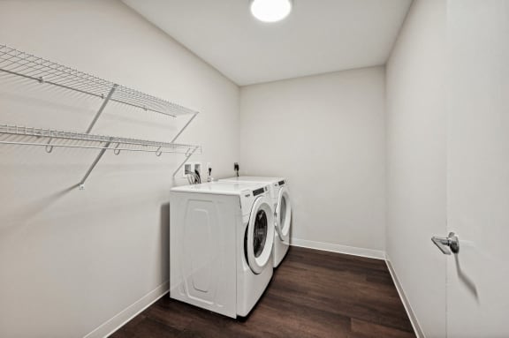 a washer and dryer in a room with a white wall and a closet