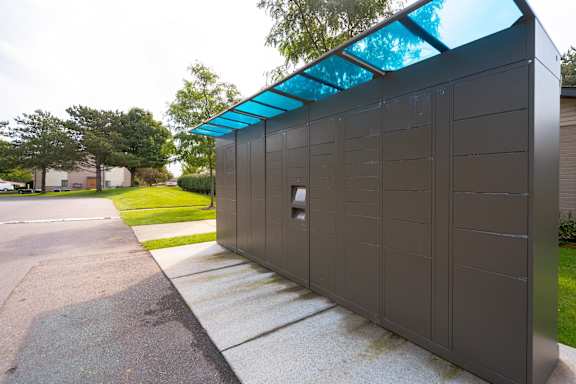 a small building with a blue roof on a sidewalk