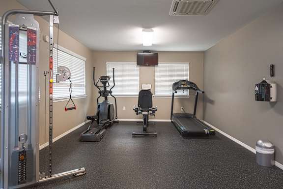 an exercise room with weights and cardio equipment at the enclave at woodbury