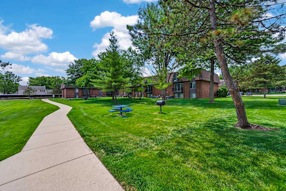 Expansive green space with picnic area at Drawbridge Apartments in Harrison Township, MI.