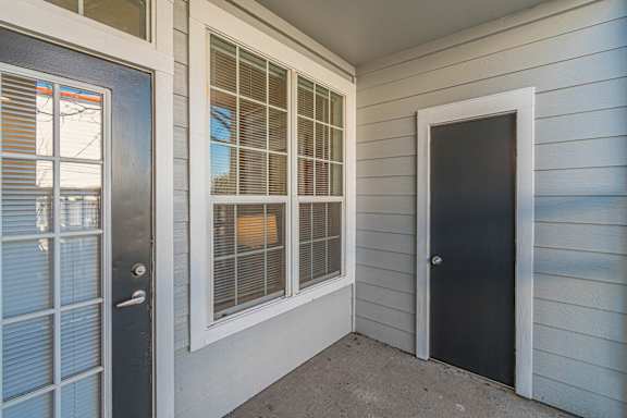 the front porch of a home with a black door