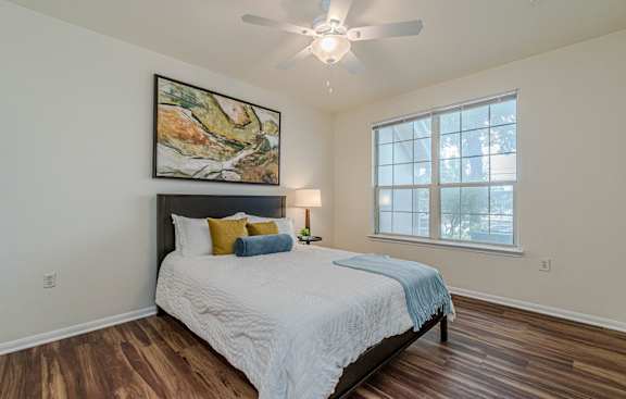 a bedroom with a bed and a ceiling fan