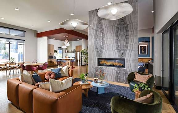 A modern living room with a fireplace and a variety of seating options.