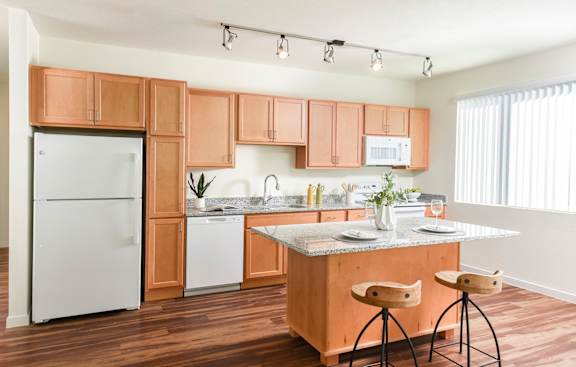 A kitchen with wooden cabinets and a white fridge.