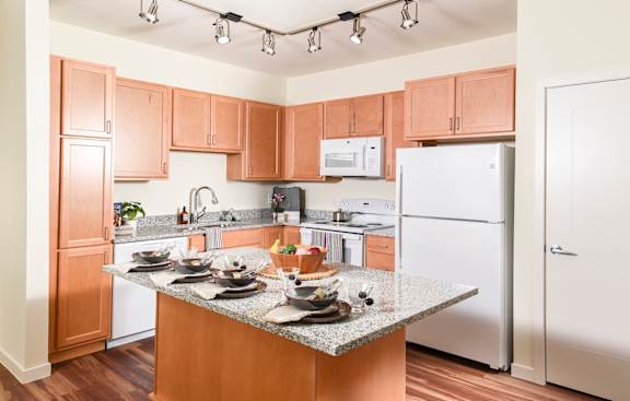 A kitchen with wooden cabinets and a granite countertop.