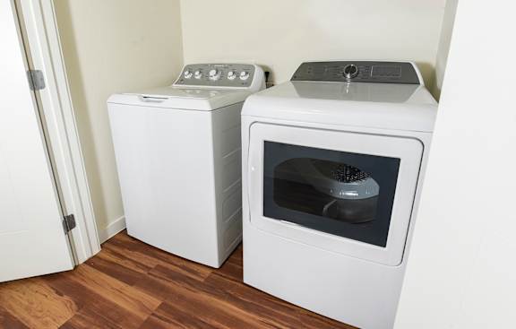 Two white ovens, one with the door open, in a kitchen.