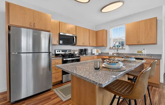 A modern kitchen with a granite countertop and wooden cabinets.