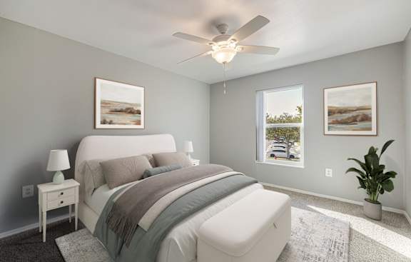 A bedroom with a large bed and a ceiling fan.