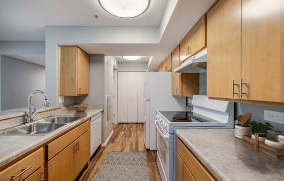 A kitchen with wooden cabinets and a white oven.