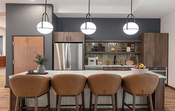 A modern kitchen with a central island and bar stools.