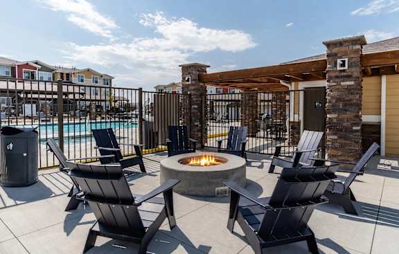 A patio with chairs and a fire pit.