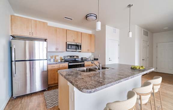 A kitchen with a granite countertop and stainless steel appliances.