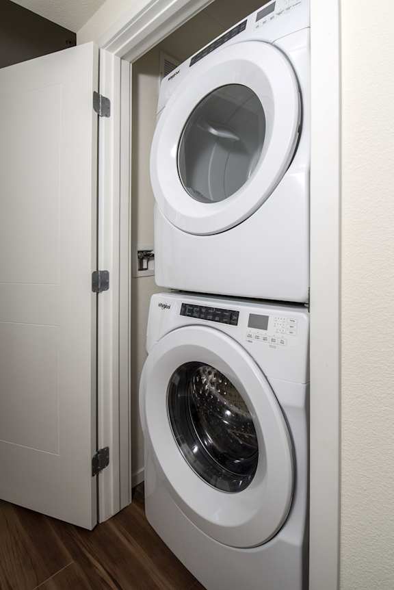 A white washing machine is in a cabinet.