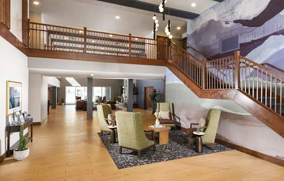 A large room with a staircase and a mural on the wall.