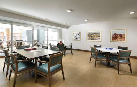A room with a table surrounded by chairs and pictures on the wall.