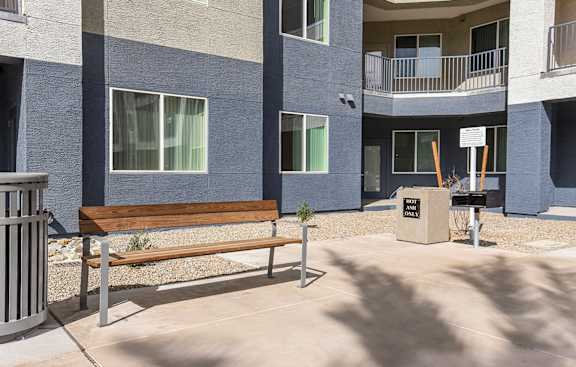 A bench sits in front of a building with a sign that says "The Park".