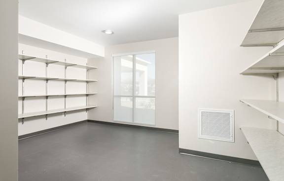 A room with a window and shelves on the wall.