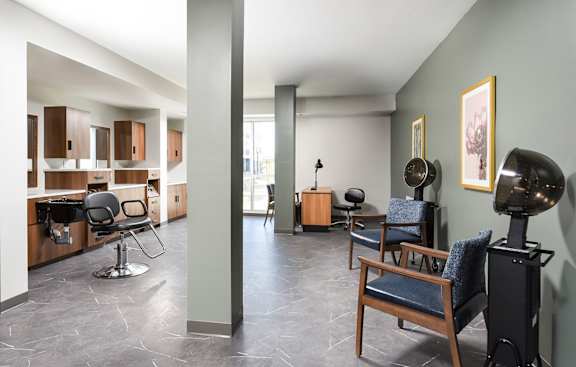 A living room with a blue chair and a black speaker.