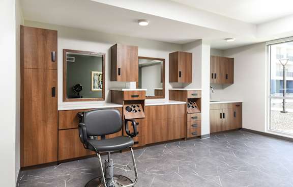 A chair is in front of a wooden cabinet with a mirror.