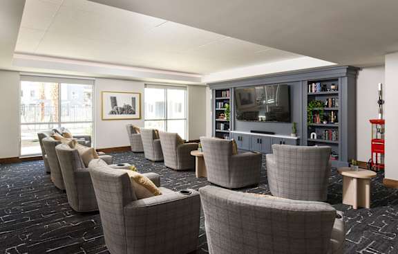 A room with grey chairs and a television.
