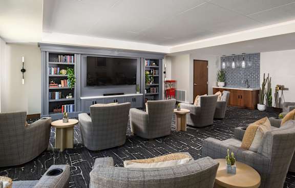 A living room with grey couches and a television.