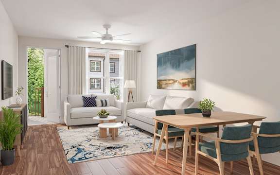 A living room with a white couch, a wooden table, and a painting on the wall.