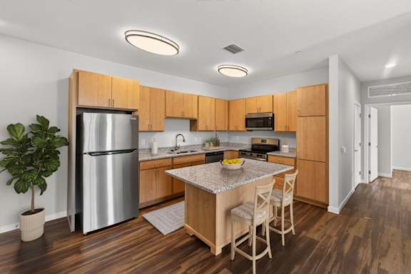 A kitchen with wooden cabinets and a stainless steel refrigerator.