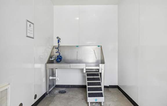A clean, empty room with a stainless steel table and a metal staircase.
