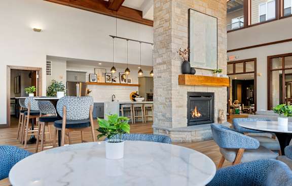 a living room with a fireplace and tables and chairs
