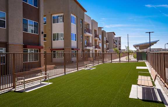 A row of apartment buildings with a grassy area in front.