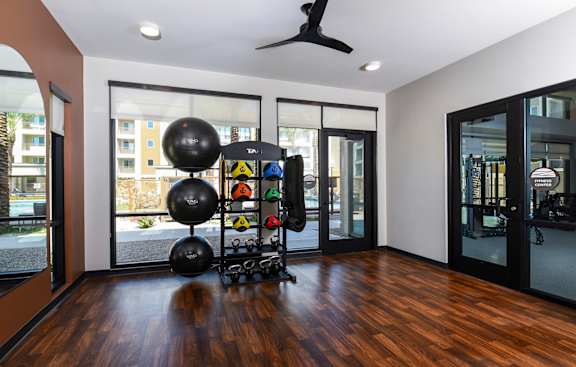 A room with a wooden floor and a black fan on the ceiling.