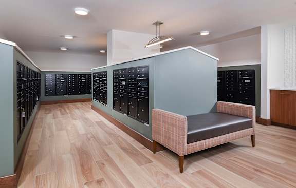 A room with a grey bench and wooden flooring.