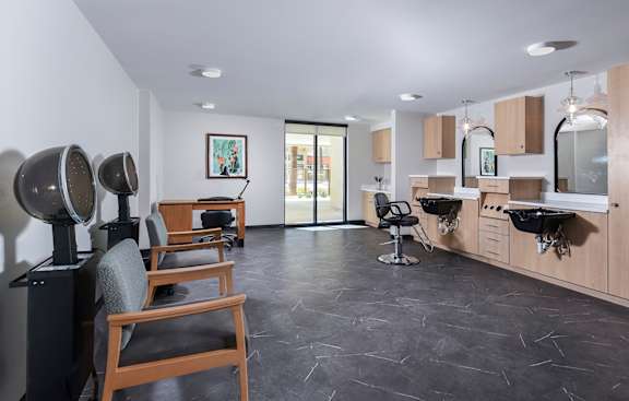 A hair salon with chairs and hairdressing stations.