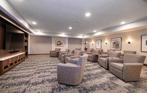 A room with grey carpet and grey chairs.