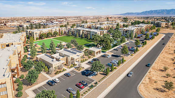 A road with cars and a green field in the middle of a city.