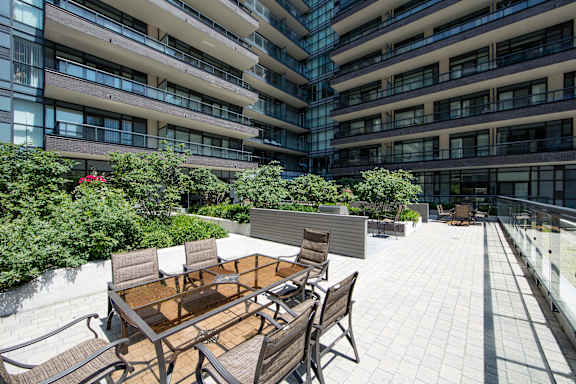 A patio with a table and chairs is surrounded by a building.