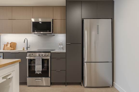A modern kitchen with a stainless steel refrigerator and oven.