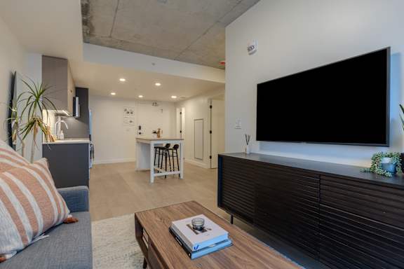A living room with a grey couch and a wooden coffee table.