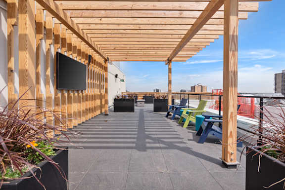 A wooden pergola with a flat screen TV mounted on it.