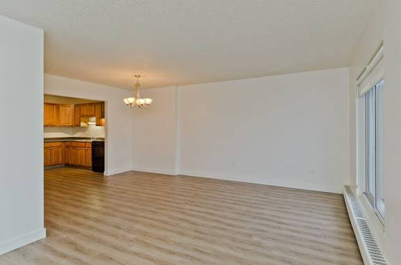 A room with wooden flooring and a chandelier.