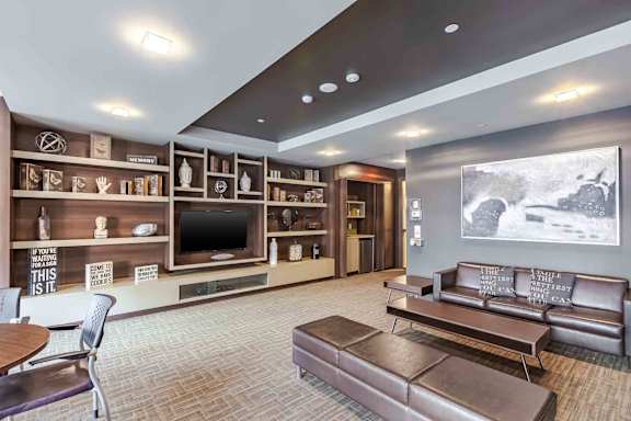 A modern living room with a flat screen TV and leather couch.
