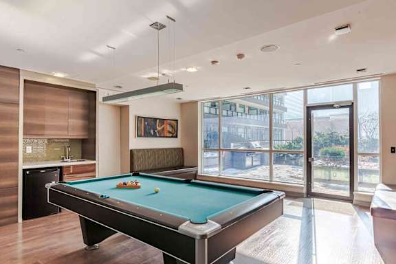 A pool table in a room with a view of the outside.