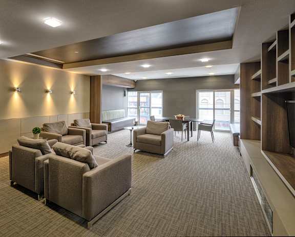 A spacious waiting room with comfortable seating and a television.