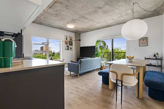 A modern living room with a grey sofa and a white table.