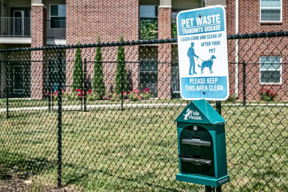 a sign on a fence in front of a dog park